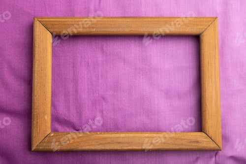 Preview: Wooden frame on smooth cotton purple tissue. Top view, natural textile background.