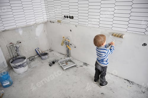 Preview: Adorable little boy painting wall with special brush.