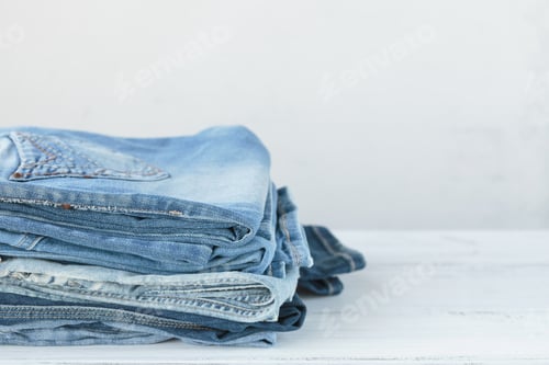 Preview: Stack of blue jeans on white background