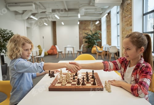 Preview: Respect. Adorable little friends, caucasian boy and girl shaking hands after match, playing chess