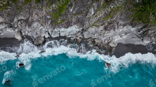 Preview: Aerial view of turquoise waves crashing against rocky shoreline in Taiwan during daylight