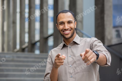 Preview: A confident man wearing a watch points directly at the camera, engaging the viewer with his gesture
