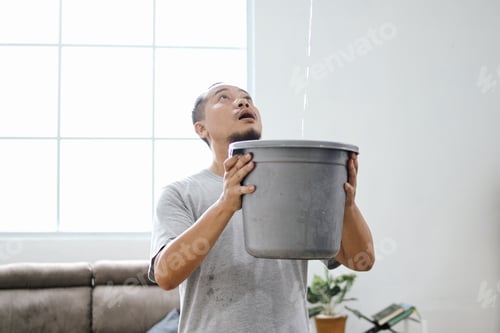 Preview: Man Collecting Water From Damaged Roof