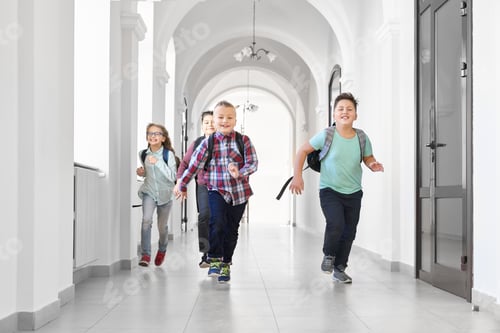 Preview: Happy pupils running forward on corridor of school
