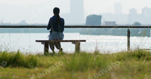 Preview: Woman enjoy the seaside and sitting on the bench