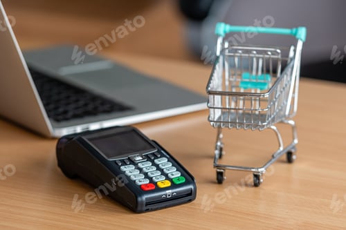 Preview: credit card terminal on table in the store with credit card, laptop and mini shopping cart on table