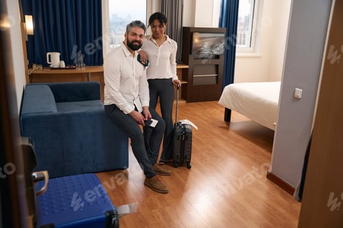 Preview: Happy interracial tourist couple in luxury suite