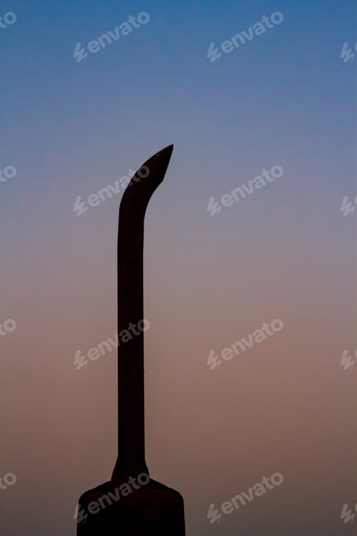 Preview: A vertical shot of a tractor exhaust in silhouette in the morning.