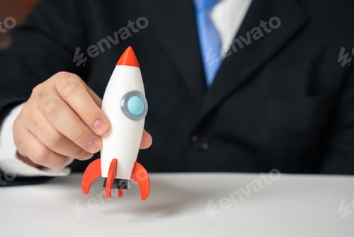 Preview: A businessman holds a startup rocket in his hand. Business launch. Innovation momentum