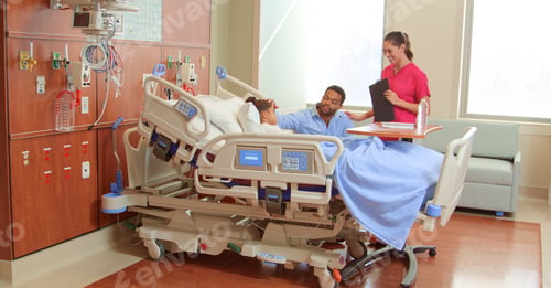 Preview: Female Doctor Or Nurse Wearing Scrubs Meeting With Father Visiting Daughter In Hospital Bed