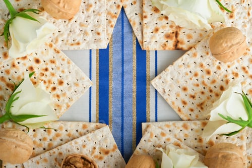 Preview: Passover celebration concept. Blue Star of David made from matzah, white and yellow roses, kippah an