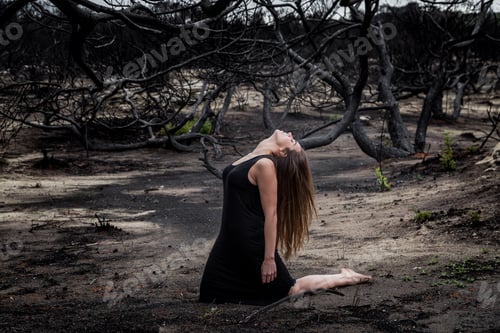 Preview: Woman posing on ground near dry trees