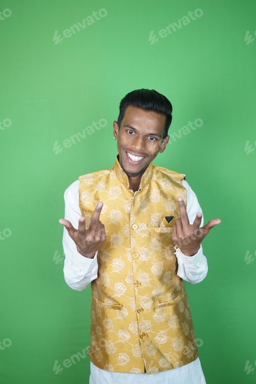 Preview: Indian men smiling with his fingers up on the green background
