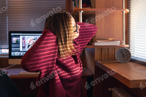 Preview: A woman looks through the blinds at the early morning sunlight.