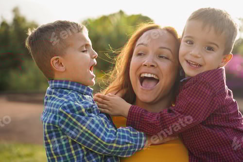 Preview: Happy mother having fun with her children at city park