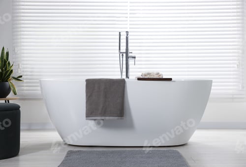 Preview: Stylish bathroom interior with ceramic tub, terry towels and houseplant