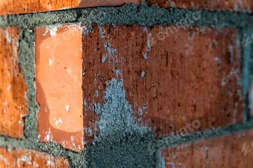 Preview: Close up of bricklaying industrial installing bricks on construction site wall