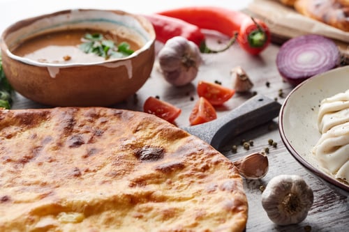 Preview: Imereti khachapuri, khinkali and soup kharcho on table with vegetables