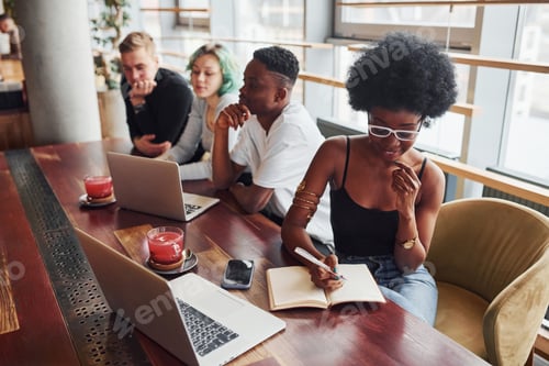 Preview: Black woman sitting in front of group of multi ethnic people