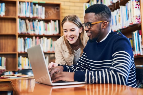 Preview: Shot of a young woman looking on while a male student works on a laptop