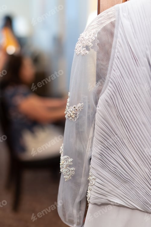 Preview: Close-up shot of the details of the white bridal gown with blurred background