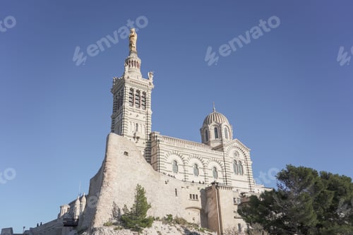 Preview: Low-angle shot the cathedral of Notre dame de lagarde in Marseille, France atop a rocky outcrop