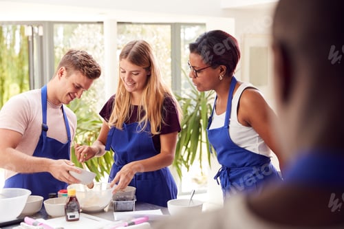 Preview: Male And Female Adult Students Measuring Ingredients In Cookery Class In Kitchen