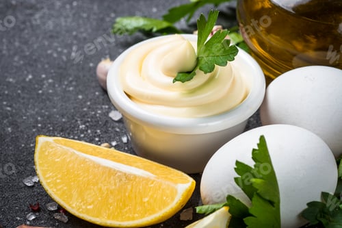 Preview: Mayonnaise sauce on black stone table.