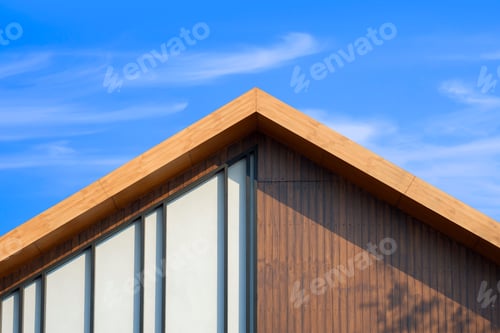 Preview: Wooden gable roof with battens decoration of retro house against cloud on blue sky background