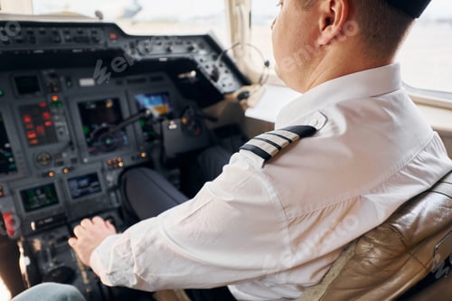 Preview: Calm atmosphere. Pilot in formal wear sits in the cockpit and controls airplane