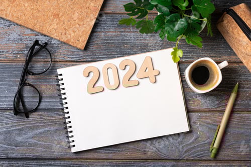 Visualização: Resoluções de ano novo de 2024 na mesa. Lista de metas de 2024 com notebook, xícara de café, planta na mesa de madeira