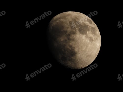 Preview: a big half moon lit up against a black sky at night