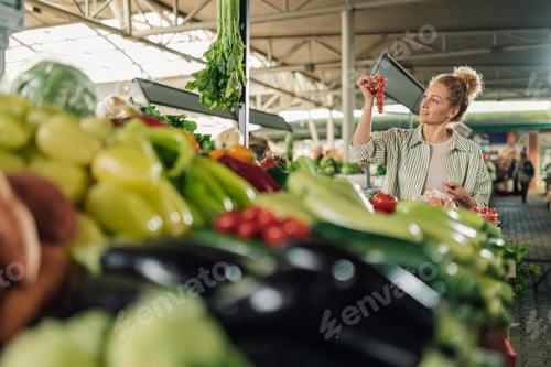 Preview: Customer holding cherry tomato in hands and buying it at food market.