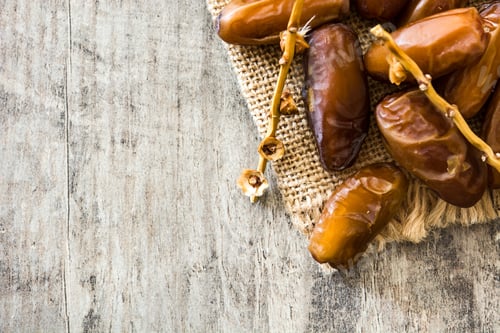 Preview: Fresh dates fruit branch on rustic wooden table background