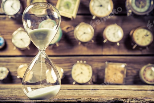 Preview: Vintage hourglass on background made of clocks