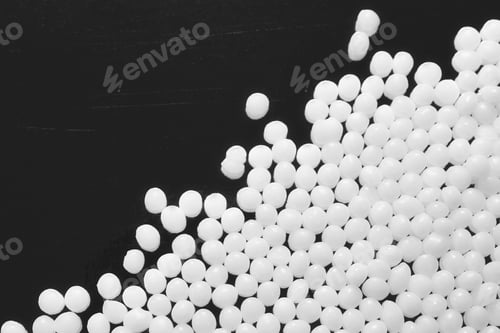 Preview: Close up picture of polyamide granules on a dark background, selective focus.