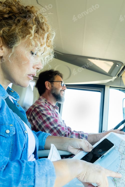 Preview: Man driving camper smiles while driving with his wife company. Concept of travel,