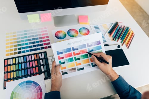 Preview: Hand designer choosing colors for doing graphic on laptop.