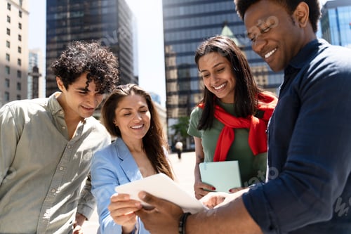 Preview: Group of young professionals using digital tablet in city
