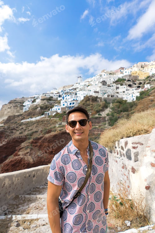 Man Smiling in Santorini with Village in Background
