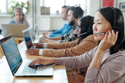 Preview: Young Asian operator consulting clients online against her co-workers