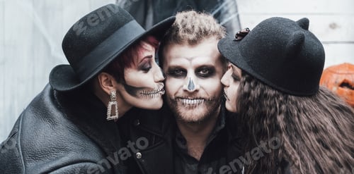 Preview: Scary family, mother, father, daughters celebrating halloween. Terrifying black skull half-face make