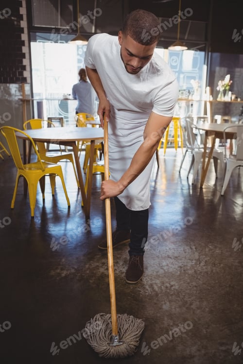 Preview: Waiter mopping floor in cafe