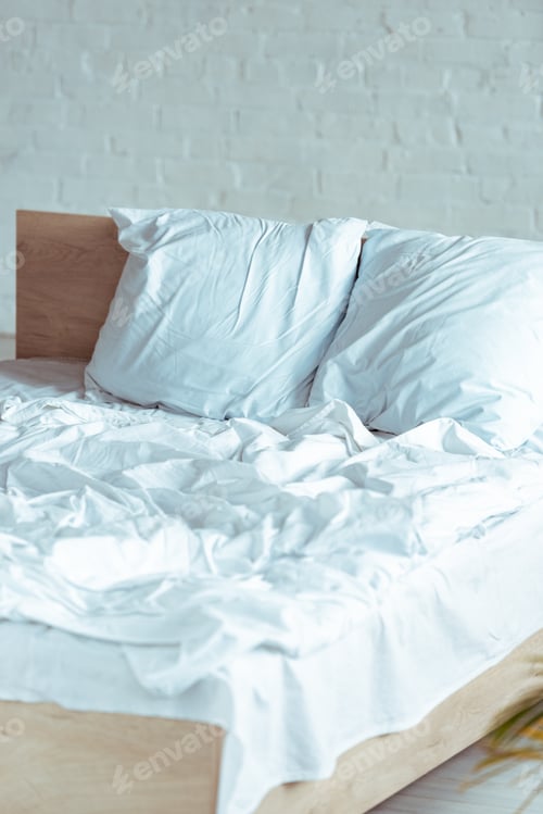 Preview: wooden and cozy bed with pillows, blanket, sheet in bedroom