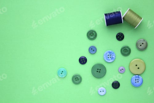Preview: Sewing items flat lay style - green and blue buttons and spools of cotton thread
