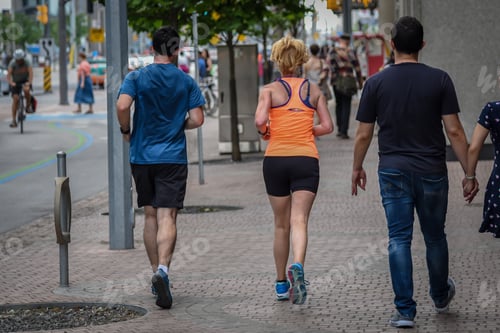 Preview: Man and woman jogging down city sidewalk