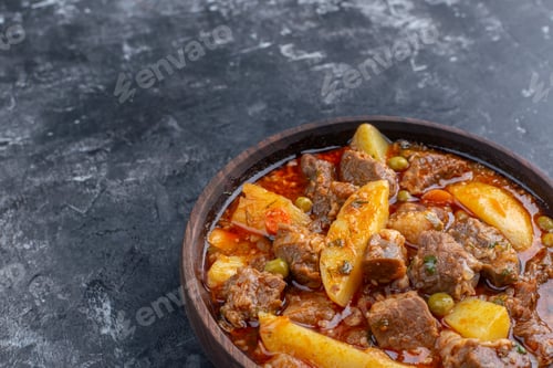 Preview: bottom half view bozbash meat soup in wooden bowl on grey background copy space
