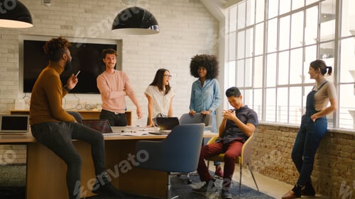 Preview: Young Multi Cultural Business Team Meeting Around Desk In Modern Office