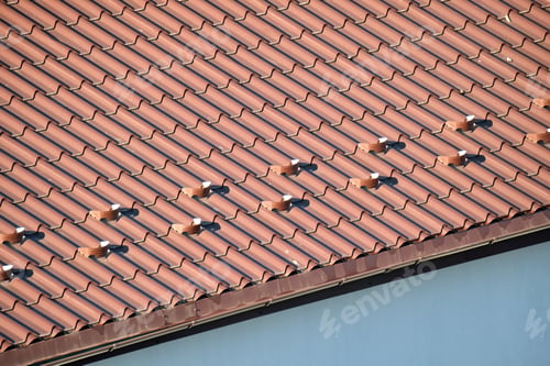 Preview: Closeup snow guard for safety in winter on house roof top covered with steel shingles. Tiled