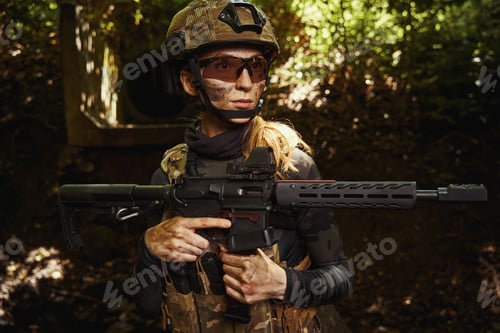 Preview: Female person in protective glasses holding gun
